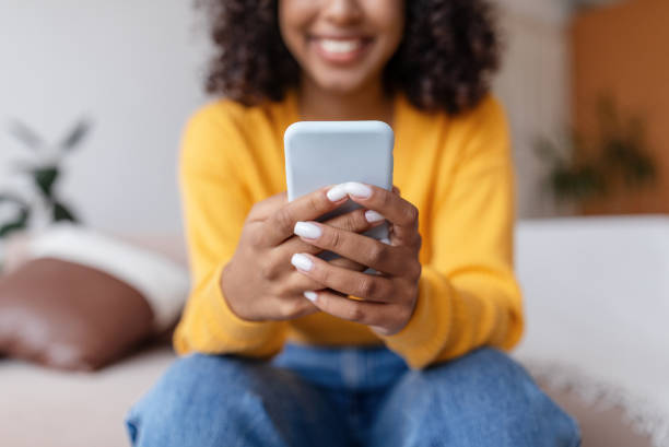 istock Unrecognizable young black woman using mobile phone, having online video call, communicating in social network at home 1479494231