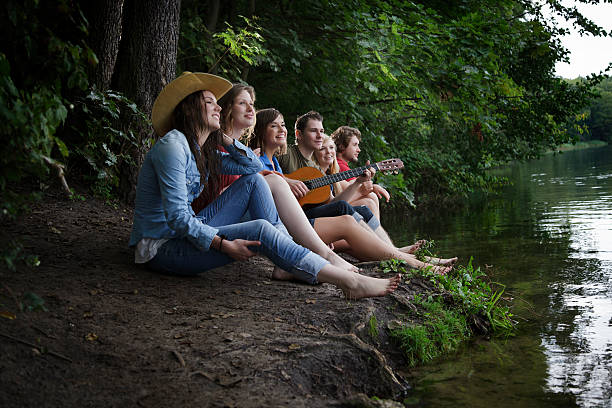 Friends on a Camping Trip Singing and Playing Guitar