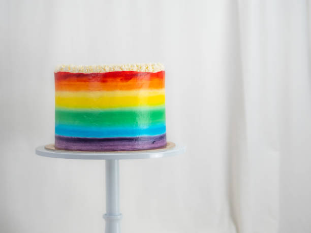 istock chef pastry baker making a frosted cup cake with rainbow colors - lgbt pride celebration anniversary 1479495420
