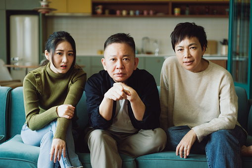 Asian family watching tv at home