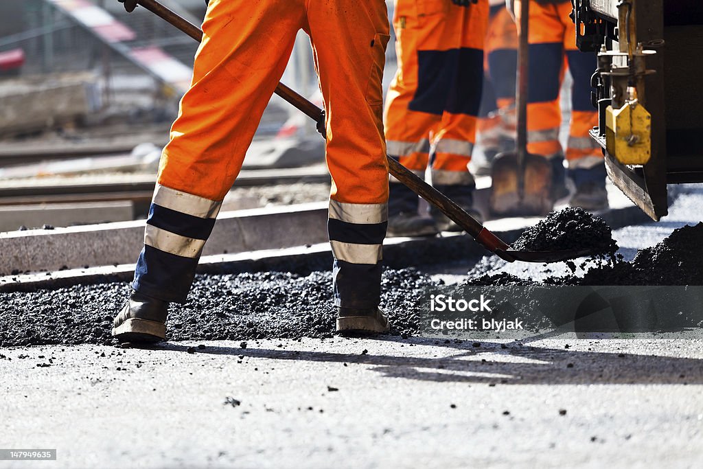 Road construction, worker with shovel Workers on a road construction, industry and teamwork Road Construction Stock Photo