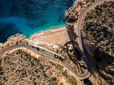 Winding road and sandy beach in the mountains. Drone point of view. Shoot directly above. Kaputas beach