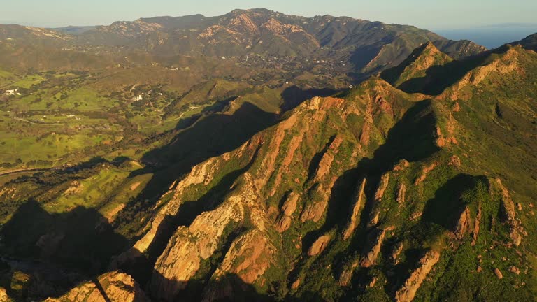 Aerial drone point of view over the beautiful green Santa Monica mountains in California at sunset