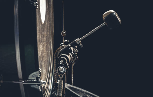 Bass drum with pedal, musical instrument on black background.