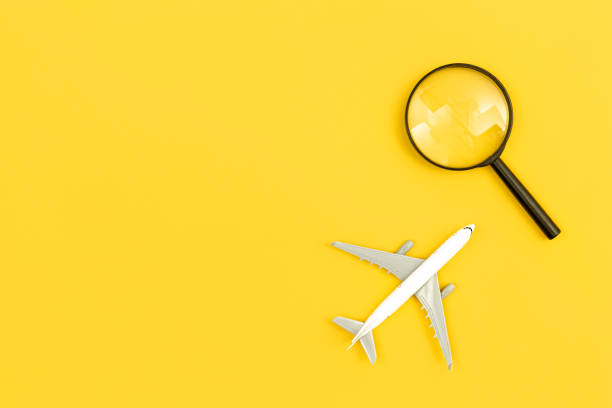 istock Airplane model and magnifier on yellow background, flat lay. 1479500682