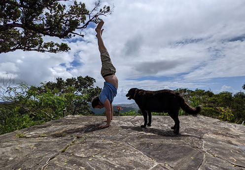 Upside Down in Paradise: A man performs a handstand next to his flat-haired retriever dog on the summit of one of Oahuâs peaks, with the stunning views of Honolulu and Diamond Head in the distance.