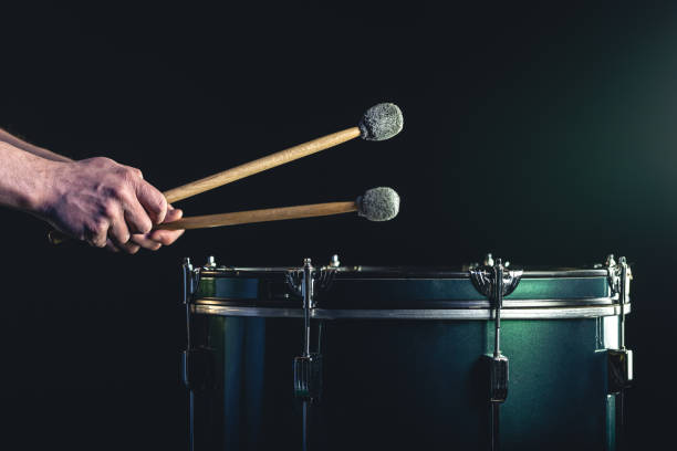 istock A man plays a musical percussion instrument with sticks on a dark background. 1479500933