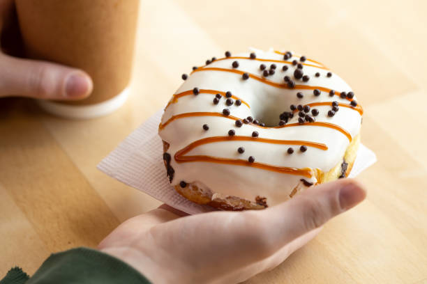 istock Appetizing donut and coffee in male hands, close-up. 1479503278