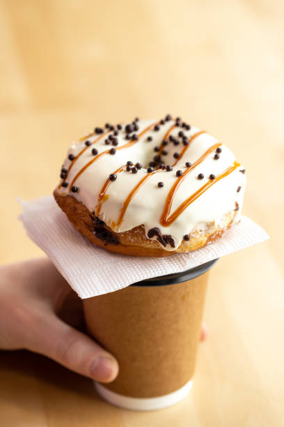 istock Appetizing donut and coffee in male hands, close-up. 1479503302