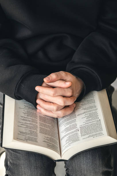 istock Open book Bible in male hands, close-up. 1479503601