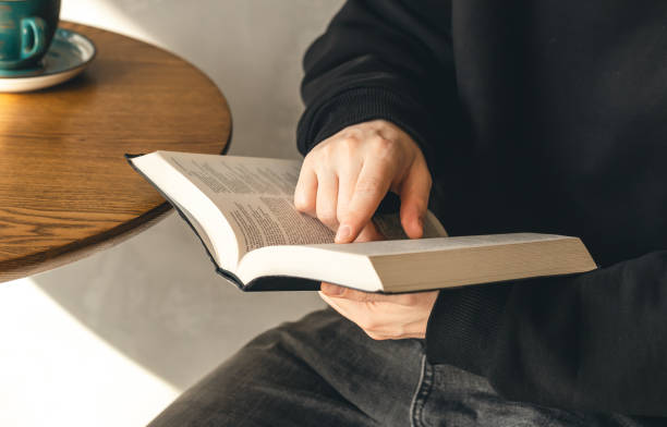 istock Open book Bible in male hands, close-up. 1479503614