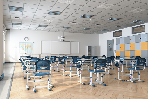 Empty Modern Classroom Interior With Desks, Blue Chairs, Cabinets And Whiteboard