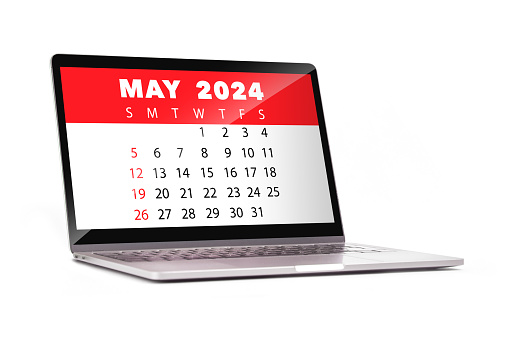 May 2024 calendar on laptop screen. Calendar in red. Studio photo taken on isolated white background.