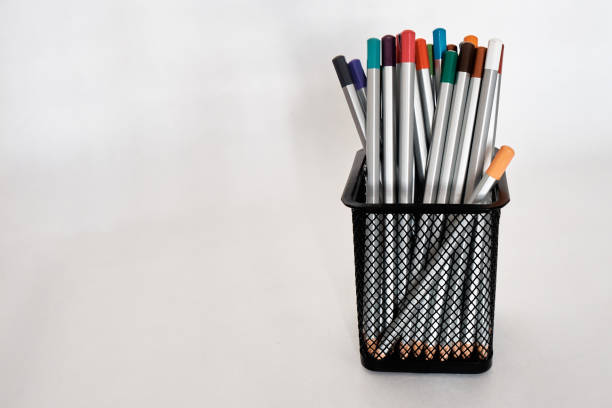 istock Colored pencils in a metal black holder or cup. Isolated on white background. There is space for text. Close-up 1479507372