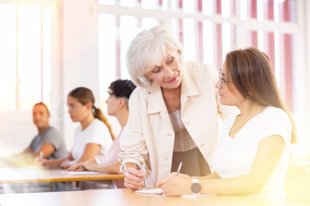 istock Female teacher helps adult student complete an assignment in university 1479511122