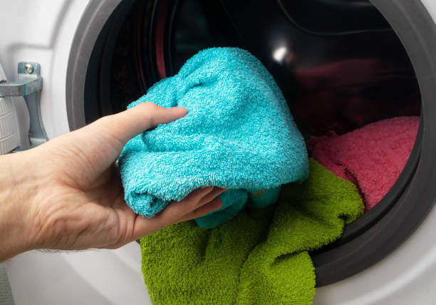 istock Hand and puts the laundry into the washing machine. 1479514066