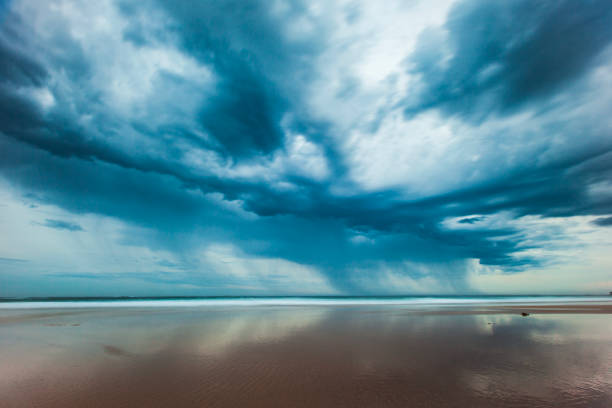 istock Coastal seascape scene with dramatic storm cloud reflecting on beach 1479516920