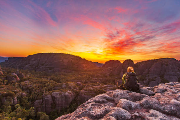 istock Hiker resting on rock watching sunrise over dramatic mountain landscape 1479517853