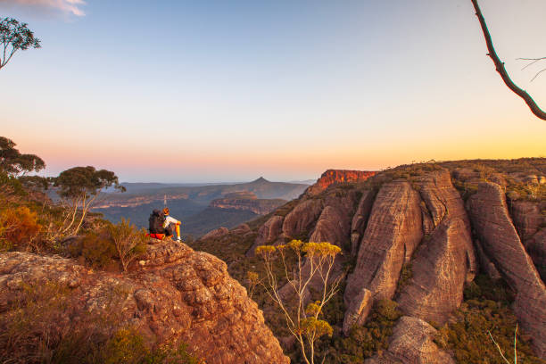 istock Hiker resting on rock watching sunset over dramatic mountain landscape 1479517983