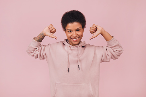 Cute smiling young woman wearing casual clothes posing on pink backdrop