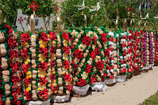 Tomar, Portugal - 11 July 2015. Trays lined up on display on the day before the festival of trays (Festa dos Tabuleiros), which takes place every 4 years in Tomar, Portugal. These are the trays that the girls will carry upon their heads in the parade. The tabuleiro (tray headdress), which must be of the same height as the girl bears 30 loves of bread each weighing 400 grams and threaded on 5 or 6 canes, separated by paper flowers and all mounted on a wicker basket topped with a crown with the cross of Christ or the dove of the Holy Ghost.