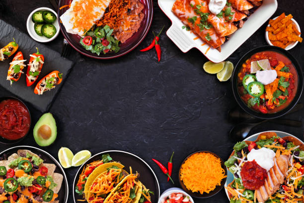 Mexican food frame. Overhead view on a dark stone background.