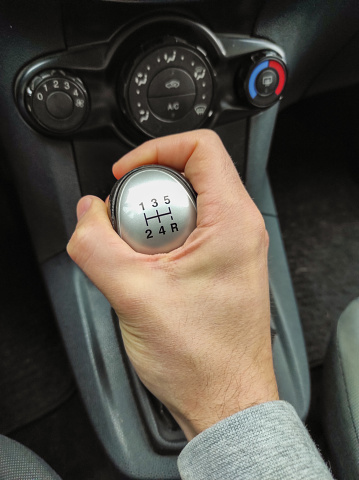 Car gear knob with driver's hand driving fast