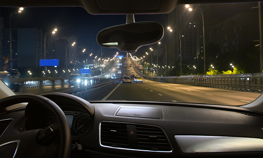 View from driving car on night traffic in city center