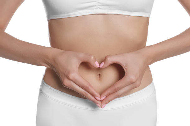 白い背景に下着を着た女性が、腹に手を当ててハートを作る、接写。健康な胃 - abdomen gynecological examination women loving ストックフォトと画像