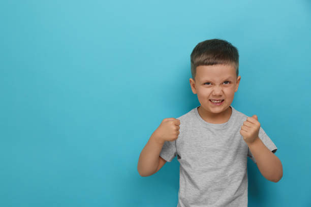 istock Angry little boy on light blue background, space for text. Aggressive behavior 1479537772
