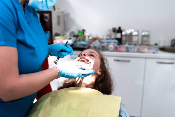 istock Dentist appointment at a dental clinic, placing braces locks on the teeth and pulling the archwire to fix it 1479542309