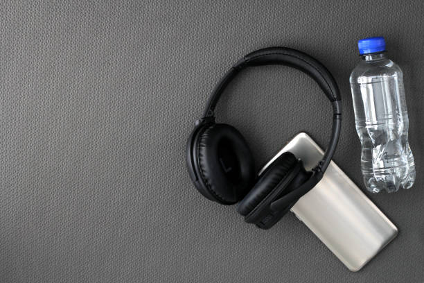 istock Mat to exercise with the necessary objects such as wireless headphones, cell phone, apple, water to hydrate, sweat towel and locker keys 1479542543