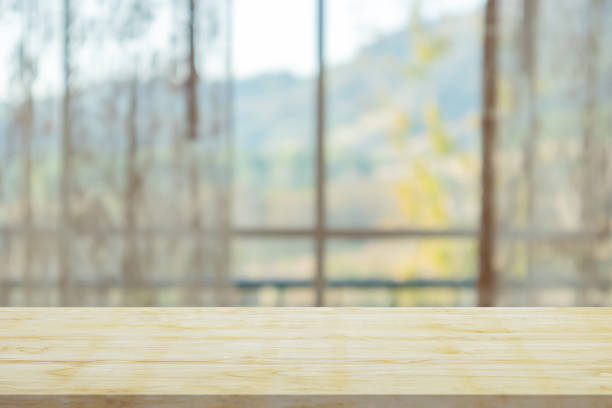 istock Empty wood table top with window curtain abstract blur background for product display 1479544465