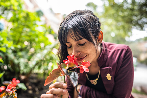 Mid adult woman smelling flowers outdoors