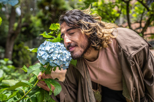 Young man smelling flowers outdoors