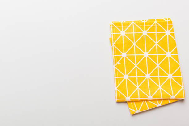 istock top view with yellow empty kitchen napkin isolated on table background. Folded cloth for mockup with copy space, Flat lay. Minimal style 1479554113