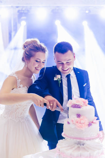 istock gorgeous tiered cake on the table. happy newlyweds are cutting a 1479554627