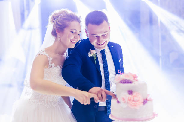 istock gorgeous tiered cake on the table. happy newlyweds are cutting a 1479554628
