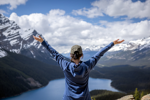 Young Woman With Arms Raised Looking at the View of Peyto Lake in Banff National Park, Alberta, Canada