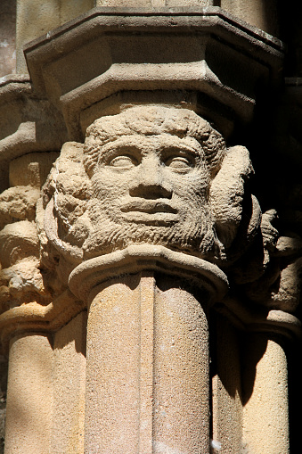 Faces on a pillar in the courtyard of the National Library of Catalonia