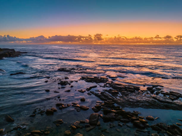 istock Summer sunrise at the seaside with clouds and rocks 1479571347