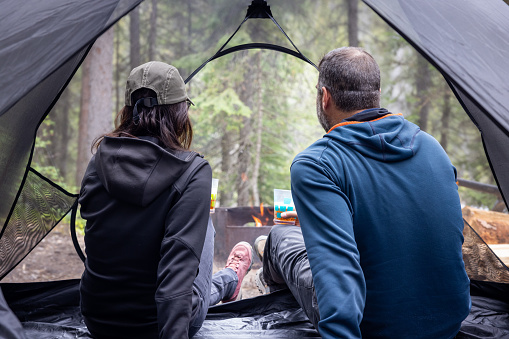 Young Couple Sitting Inside a Tent at Camping Site Close to Campfire, Yoho National Park, Bc, Canada