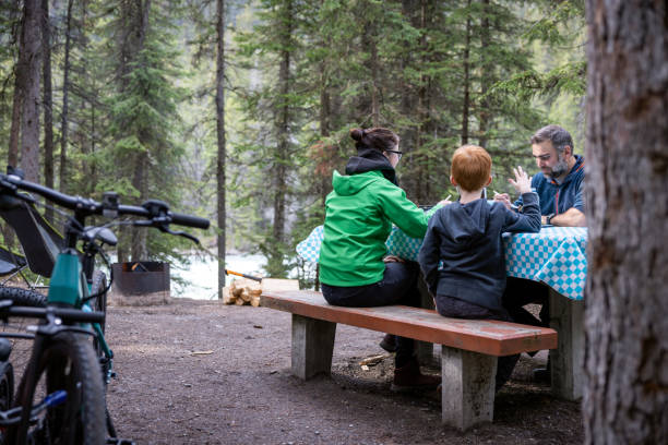 comer en familia al aire libre en el camping cerca de la fogata, parque nacional yoho, bc, canadá - bench mountain park sitting fotografías e imágenes de stock