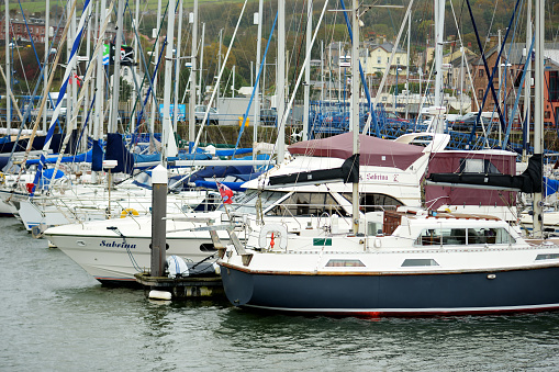 Whitehaven, UK - October 20, 2019: Colorful fishing boats and yachts at Whitehaven harbour in Cumbria, England, UK. Cold and rainy autumn day.