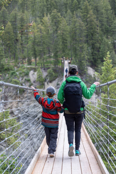 People Walking Over Wooden Suspension Bridge