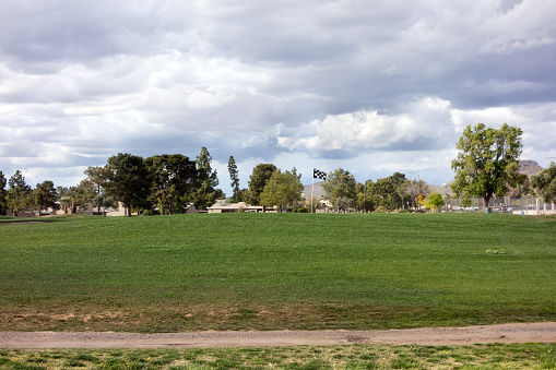Spring weather front moves in over city golf course as seen from a public street, Phoenix, Arizona