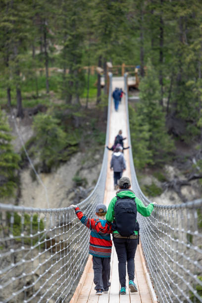 istock People Walking Over Wooden Suspension Bridge 1479574602