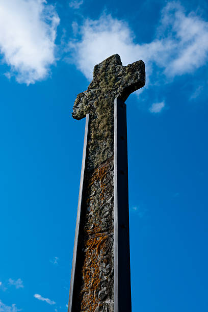 кельтский крест против голубого неба с пушистыми cluds - celtic cross cross shape blue vertical стоковые фото и изображения