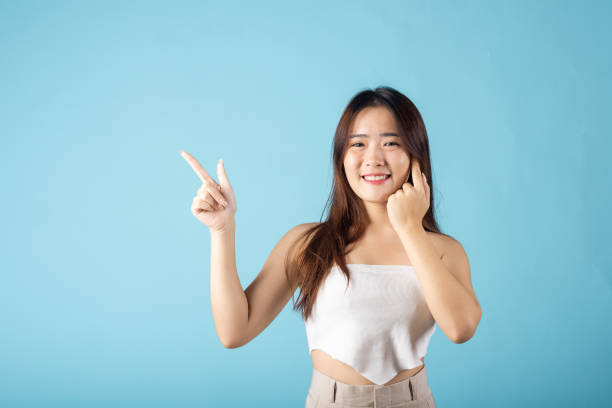 istock Asian beautiful young woman finger pointing to empty copy space 1479589062