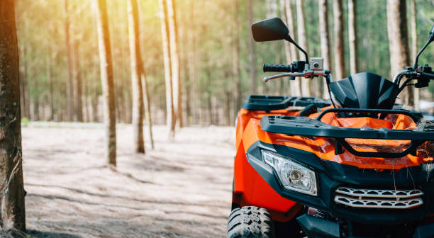 An ATV adventure through the forest at sunset, with nobody around An offroad journey through the desert on a summer evening, with an ATV and UTV crossing sand dunes and mountains in the distance, close up Extreme recreation activity concept off road vehicle stock pictures, royalty-free photos & images